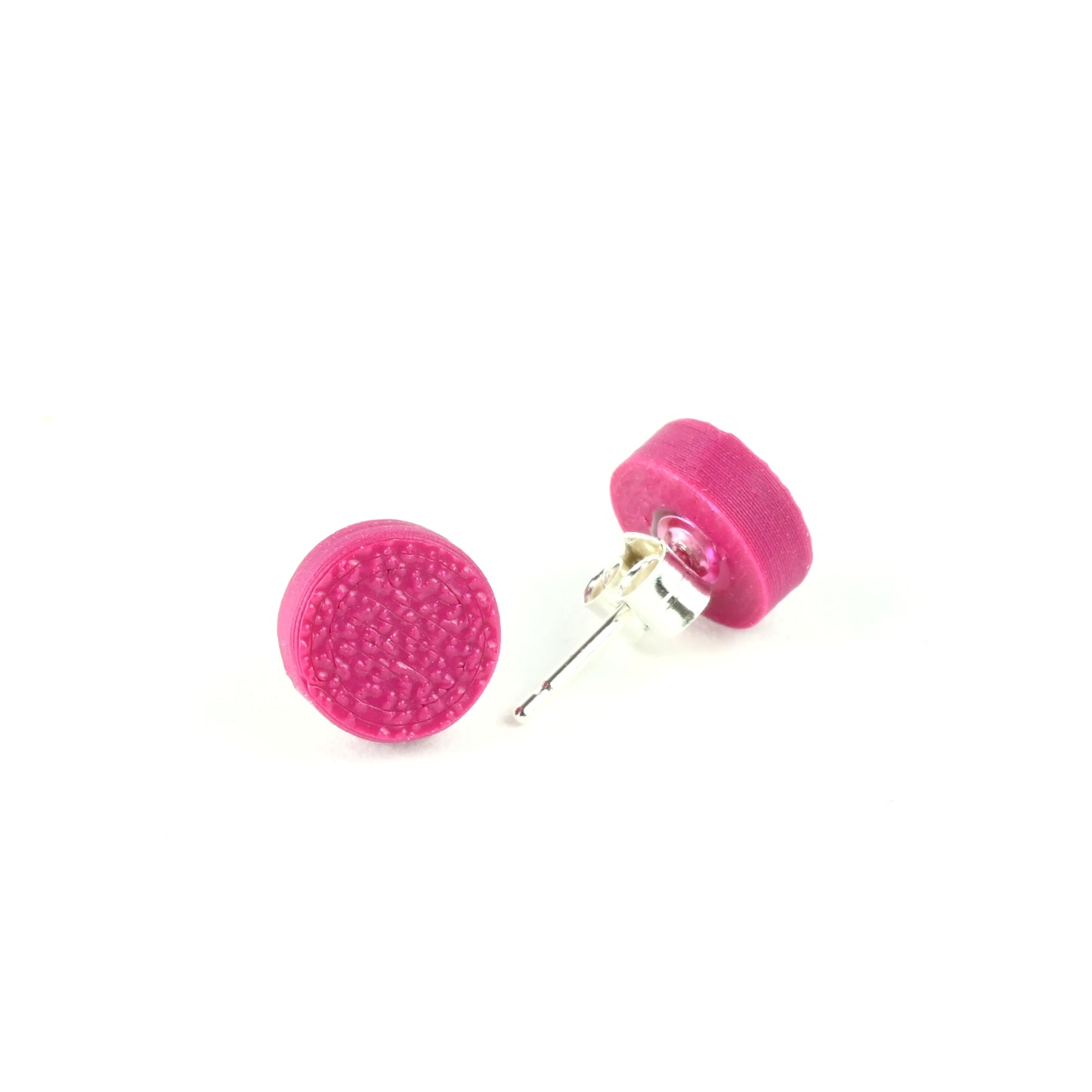 Tiny plum coloured stud earrings with textured surface on a white background.