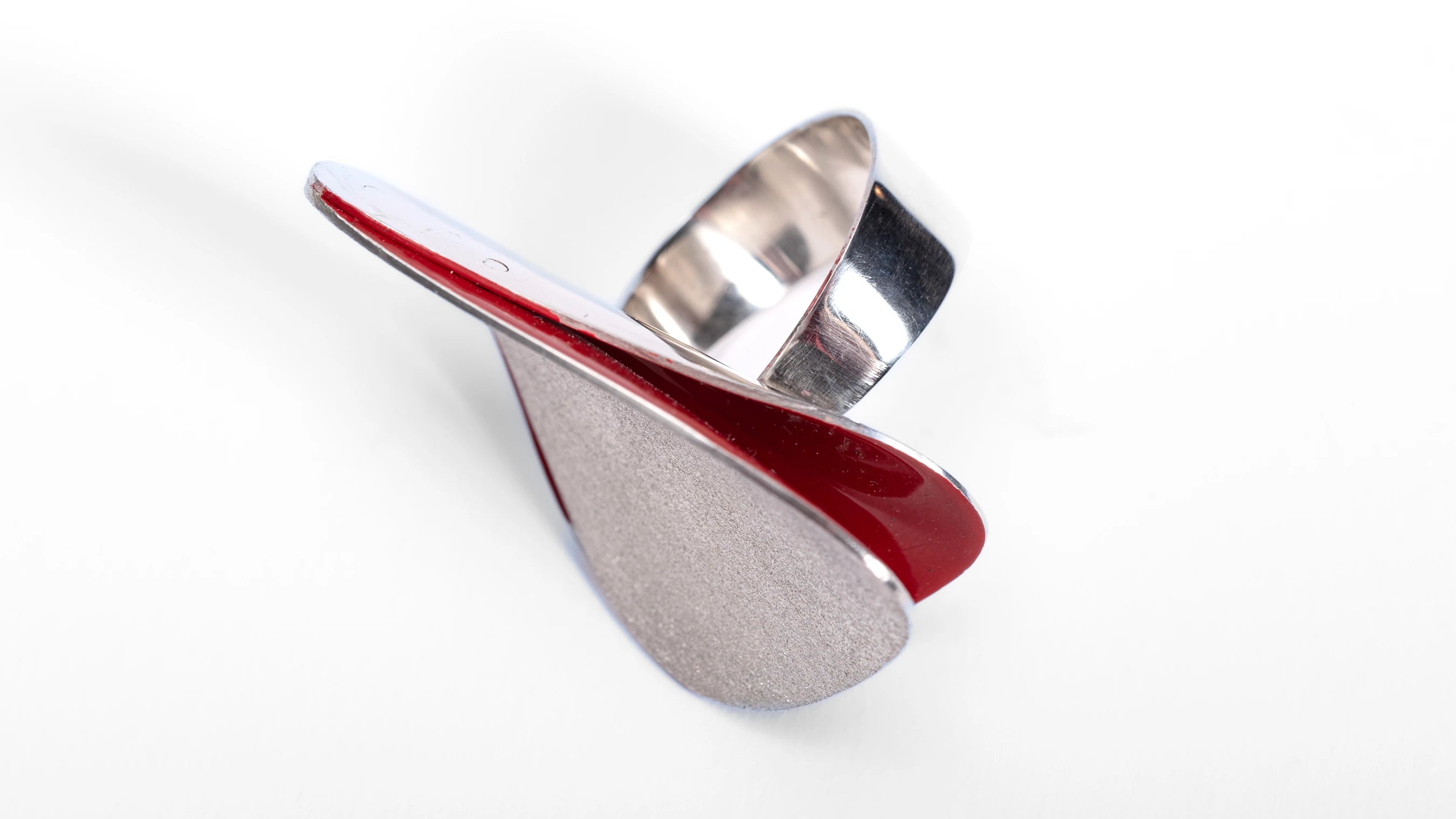 Large silver ring with frosted finish and red interior, with a shiny polished band against a white background.