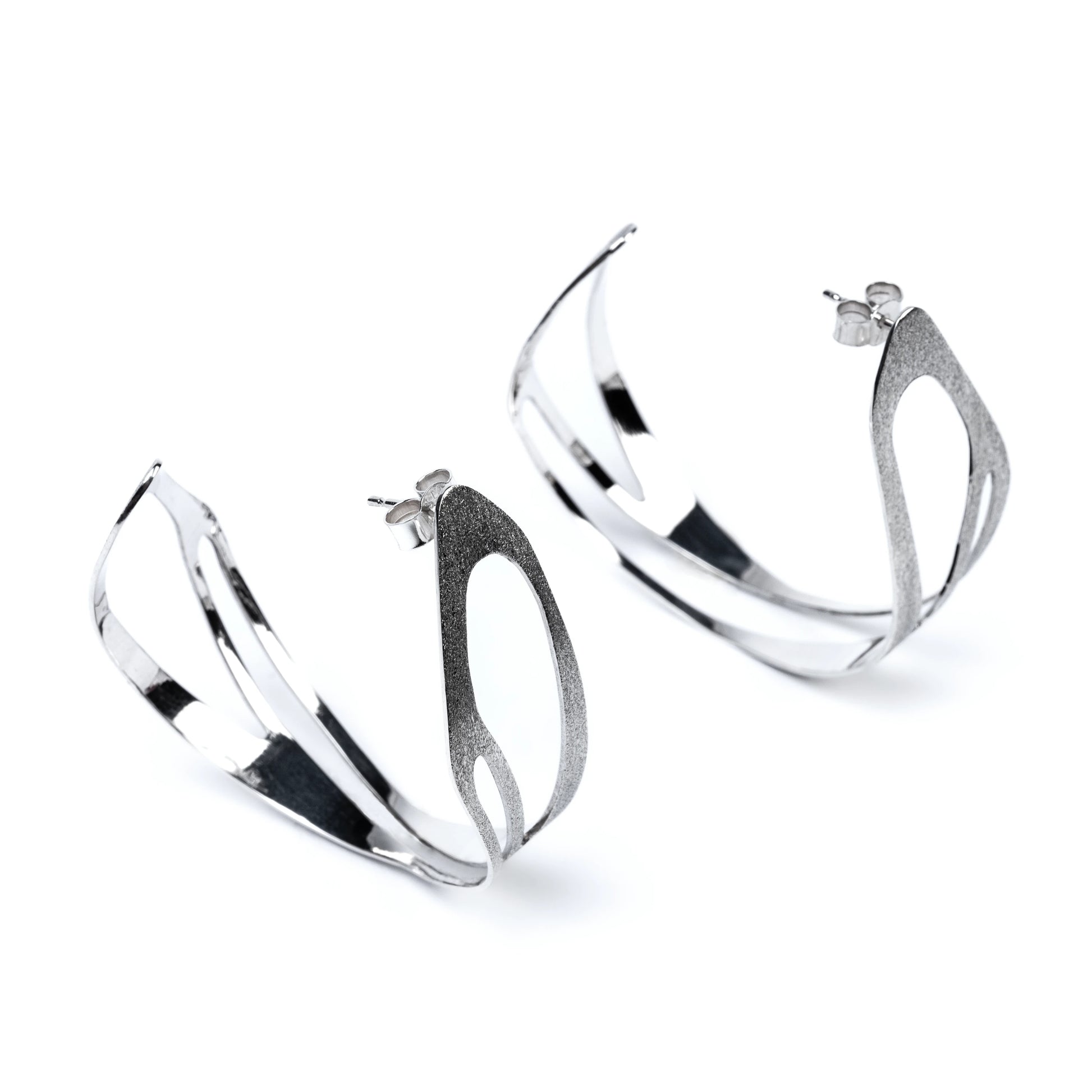Pair of silver hoop earrings with frosted texture on a white background