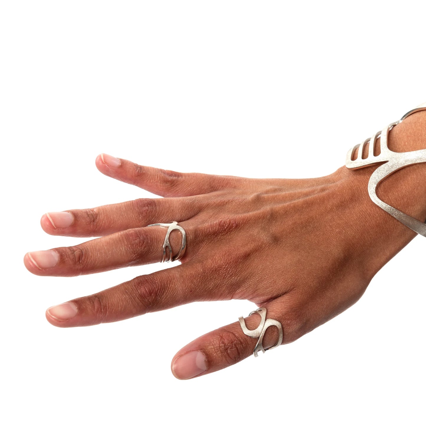 Hand wearing multiple silver rings on a white background