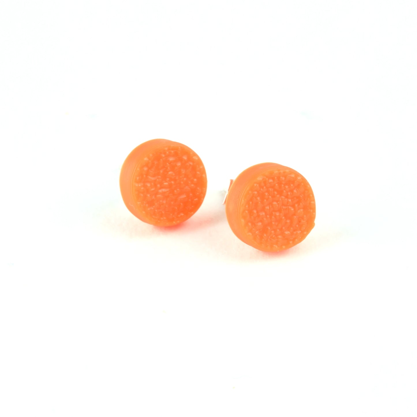 Pair of tiny orange textured round stud  earrings on a white background