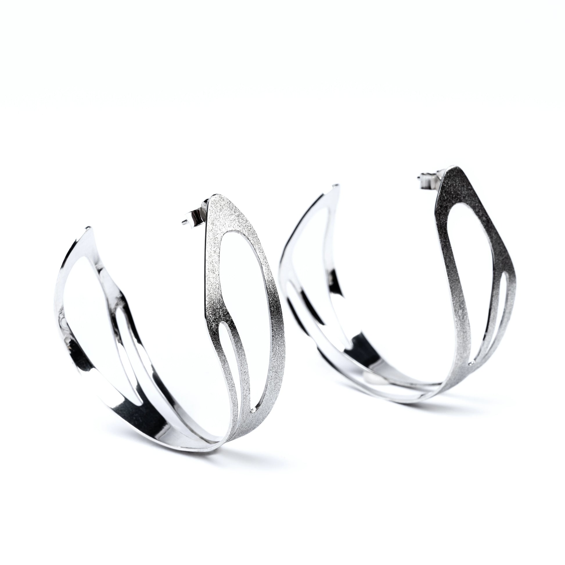 Pair of wide sterling silver hoop earrings on a white background