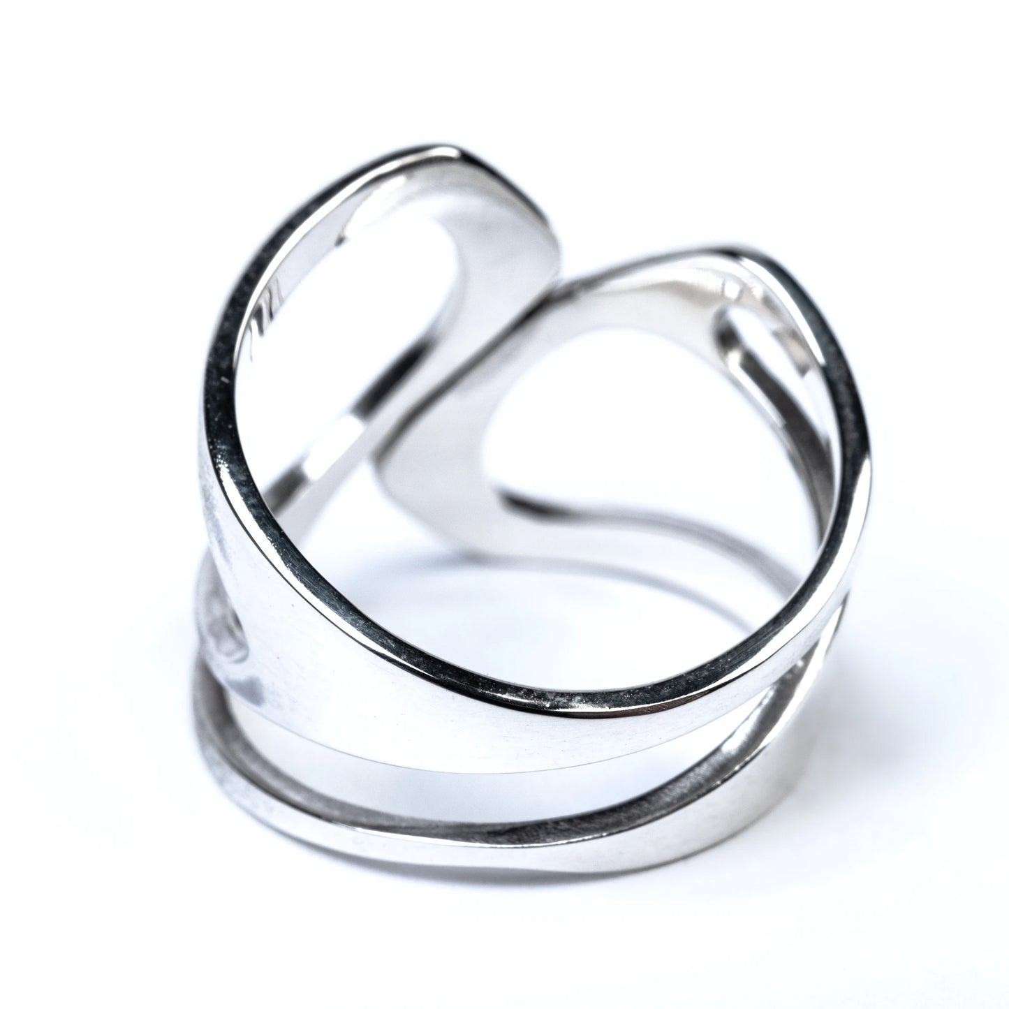 Silver ring with cut out details on a white background