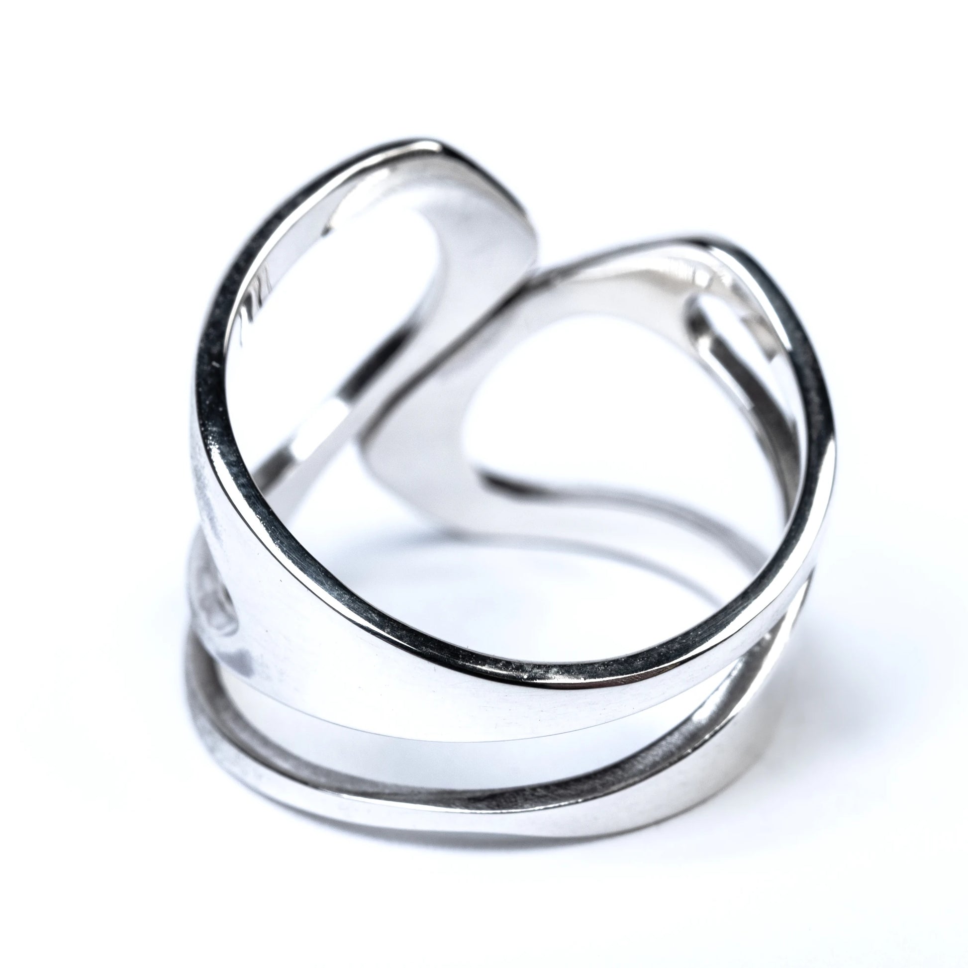 Silver ring with cut out details on a white background